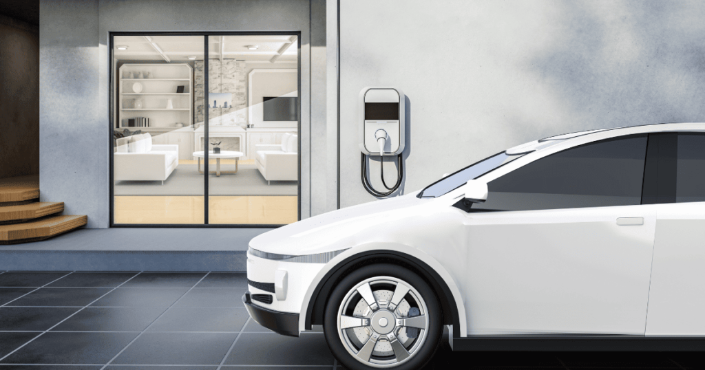 Image of a modern home with a white electric vehicle parked in the garage next to an EV charger .